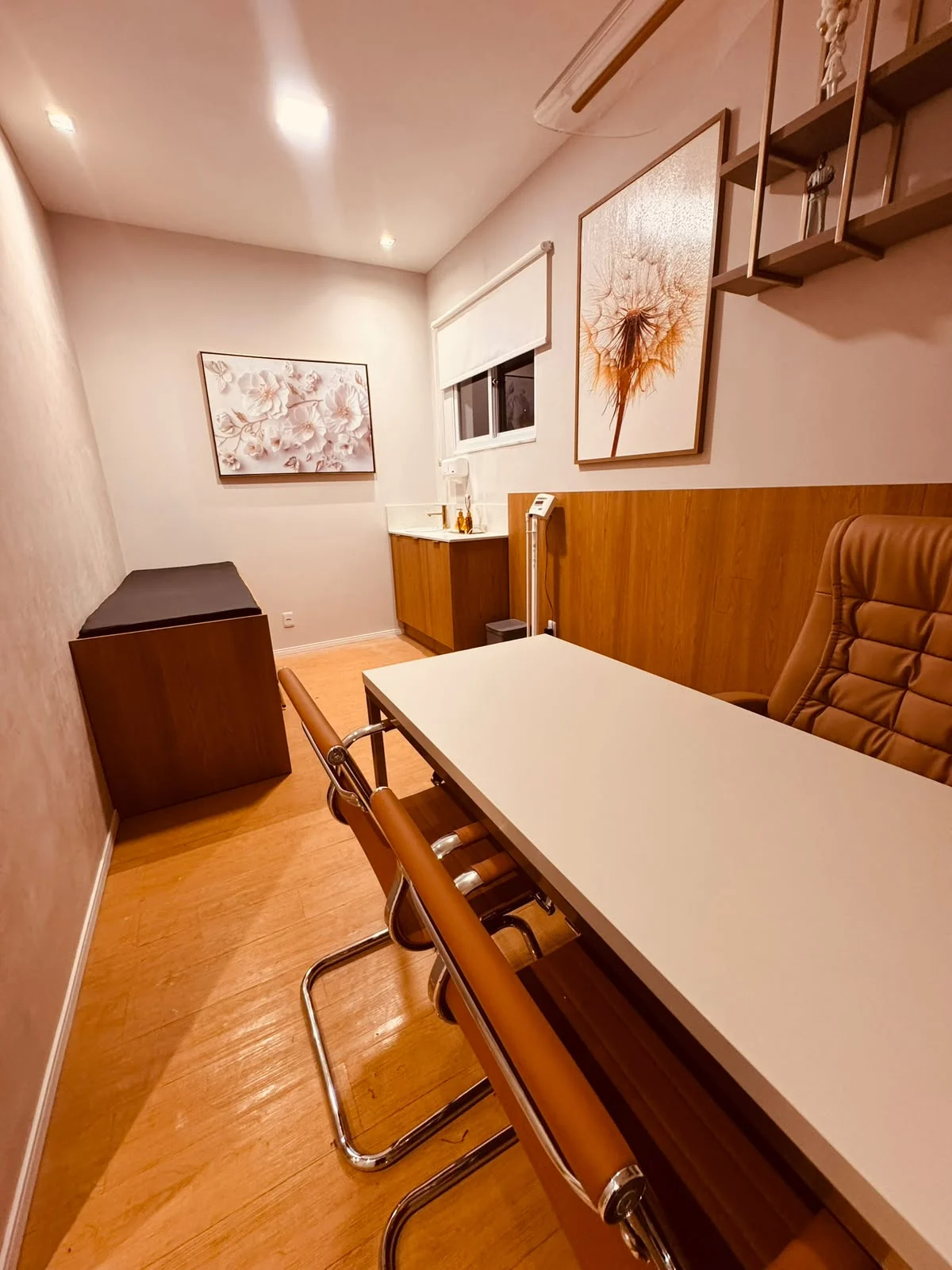 Consultório médico da Sallus com maca fixa, lavatório e mesa de atendimento