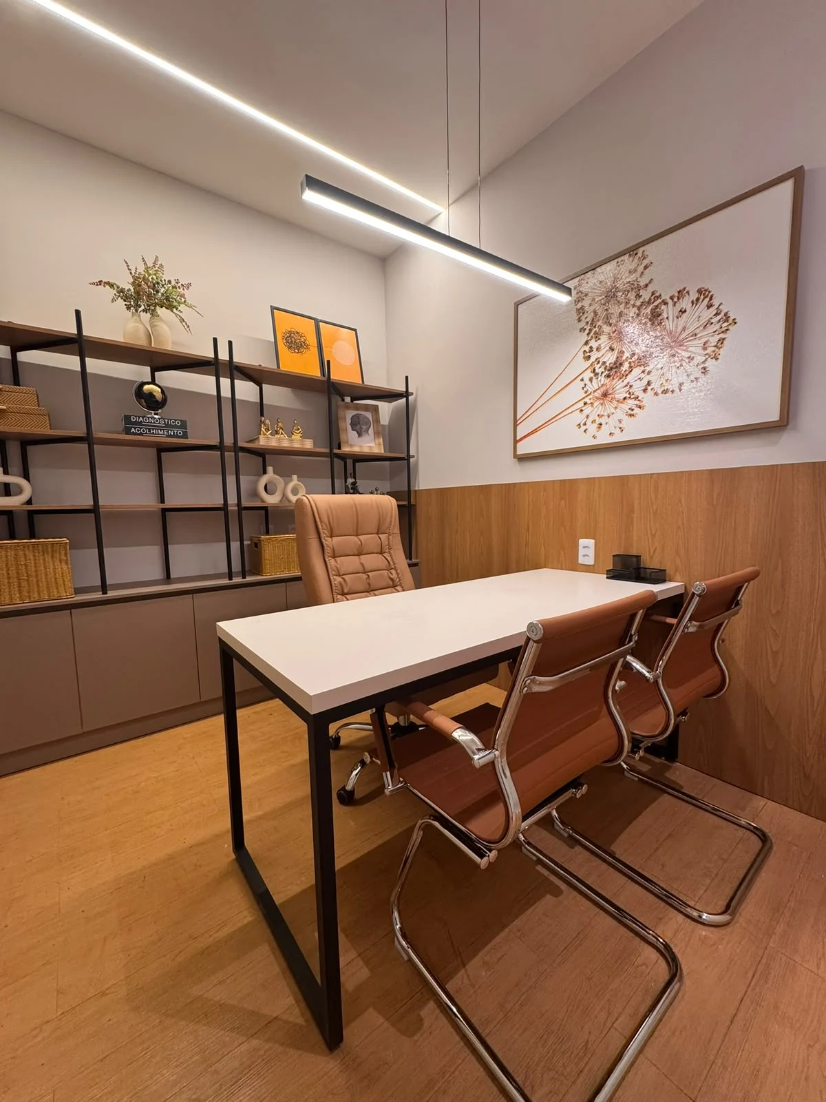 Consultório terapêutico 2 da Sallus, com mesa branca, cadeiras e quadro floral